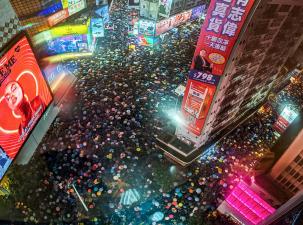 Huge crowds gather in the centre of Hong Kong all carrying umbrellas