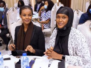 Two beautiful smiling women from Somalia sit at an awards table for the Right Livelihood Award 2022 ceremony
