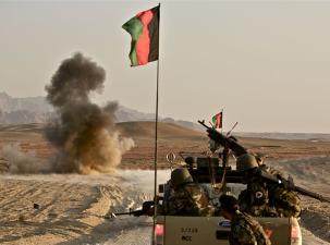 War tank with soldiers and an Afghan flag.