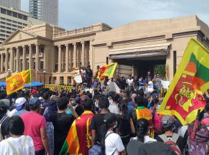 Anti-government protest in Sri Lanka in April 2022 in front of the Presidential Secretariat. Many protesters wav flags and demand a solution to their desperate economic crisis.