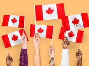 A group of hands waving flags of Canada