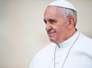 Side profile of Pope Francis wearing his white traditional ropes.