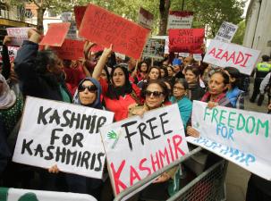 National demonstration for Kashmir at the Indian High Commission, London 10th August 2019. Many people stand behind a metal fence holding signs which say "Freedom for Kasmir" and "Free Kasmir"