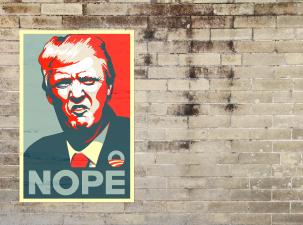 A Donald Trump poster has been pasted to a wall. His face is a vector image and he is pulling a face. Underneath in large letters its says 'Nope'.