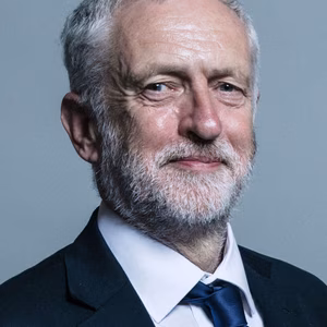 Jeremy Corbin portrait. He is shown from the shoulders up, facing slightly to the right while looking directly into the camera lens with a calm, pleasant expression.
