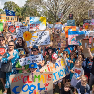 Colourful scene of many young children holding signs about climate change 