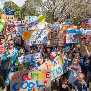 Colourful scene of many young children holding signs about climate change 