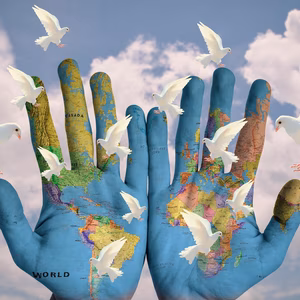 Two open palms are painted with a map of the world, in the background there are white doves in the air in front of a blue cloudy sky