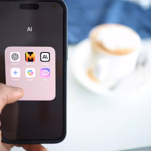 A person holds a phone in their hand with the AI screen open showing all of the available AI apps to download.
