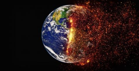Image of the Earth on a black background - half of the Earth is normal and the other half is engulfed in flames mimicking the climate crisis