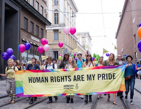 Amnesty International March through Finland, people hold a large banner displating the words 'human rights are my pride'
