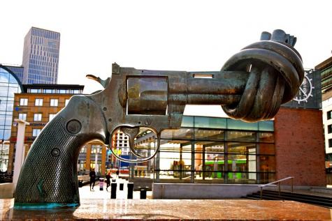 Metal statue of a gun with the barrel tied in a town centre