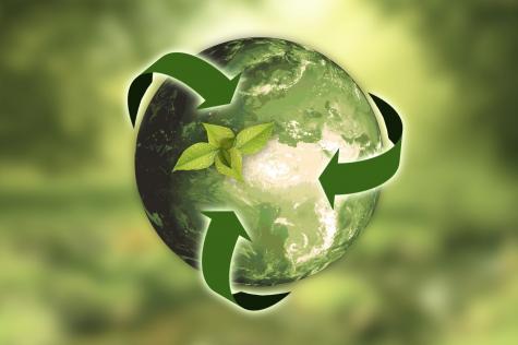 Green planet Earth surrounded by three green arrows symbolising recycling infront of a green leafy background