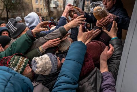 After 30 days without food, gas or electricity, residents of Bucha put their hands out to recieve bread from the UKraine millitary