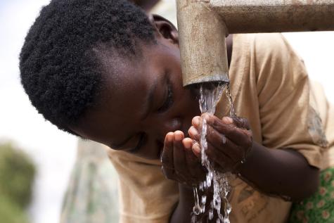 A young child from Lonjezo Community Based Child Care Centre, in the central region of Malawi accessing clean water from a borehole installed by Feed the Children