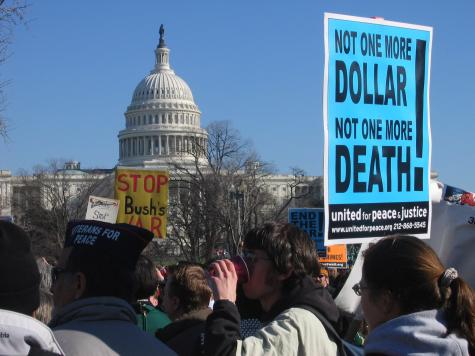 Anti-war protesters gather infront of the Whitehouse to protest the war, a large blue poster in the foreground reads 'Not one more dollar, not one more death.' in Iraq