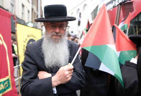  A Jewish man with a Palestinian flag at  a protest over the ongoing Israeli crimes against the Palestinian population of Gaza and the West Bank
