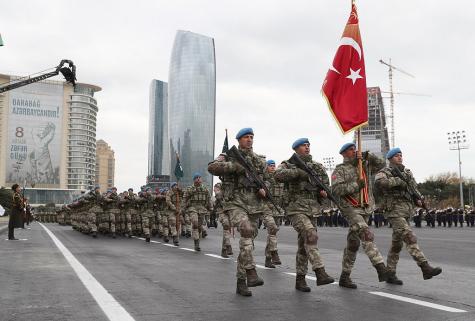 Many Turkish soldiers wearing their combat gear march down the street in a victory parade dedicated to Victory in the Patriotic War at the Azadlig Square