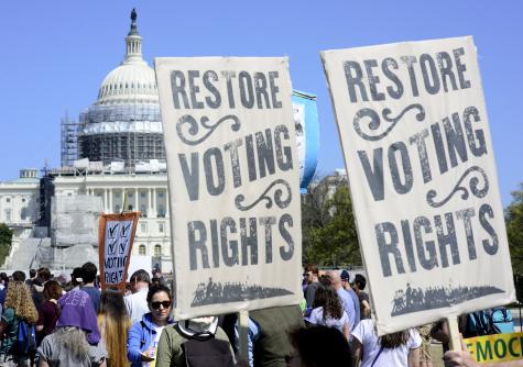 Around 7,000 anti-corruption voting rights activists gather near the US Capitol for a rally and march. The event was staged by a coalition named Democracy Awakening. Protesters are holding signs which say 'Restore voting rights'.