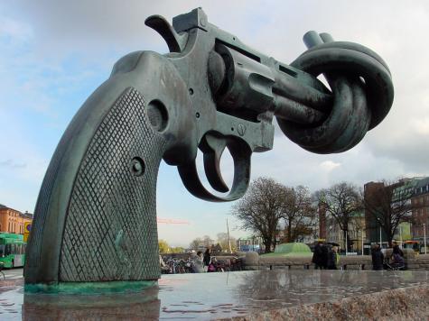 A metal statue of a gun with a knot in the barrel stands in Malmo, Sweden