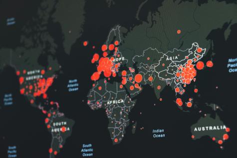 Dark map of the world displaying various pandemic hotspots with different sizes of red circles depending on the amount of cases