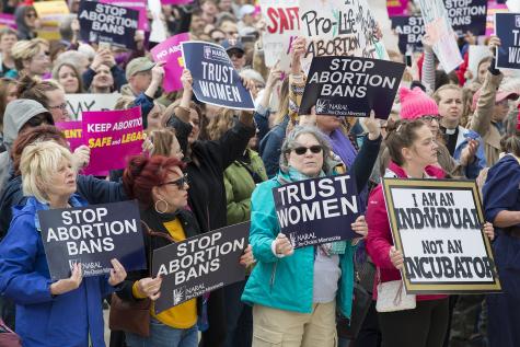Around 3,000 people met outside the Minnesota state capitol building to protest against new laws banning abortion. There are many women holding large signs which say things like 'Stop abortion bans' and 'Trust women'