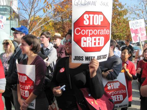 Protest at Goldman Sachs DC by Jobs With Justice. Protesters are holding signs which say 'Stop corporate greed'