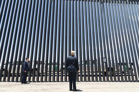 President Donald J. Trump stands before a plaque Tuesday, June 23, 2020, commemorating the 200th mile of new border wall along the U.S.-Mexico border near Yuma, Arizona