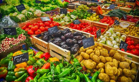 A large variety of vegetables sit at a stall on a market