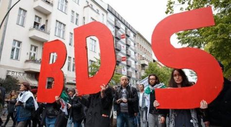 Pro-Palestine supporters hold up giant red letters BDS representing the boycott movement against Israel.