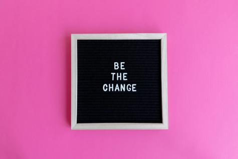The words 'Be the change' are written in a frame on a pink background.