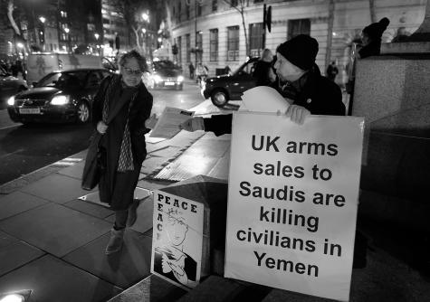 A female protester in central London hands out leaflets highlighting Britain's arms exports to Saudi Arabia and how they "fuel the conflict" and humanitarian crisis in Yemen.
