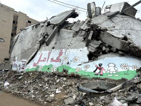 A mural painted on the rubble of a destroyed building in Al Thawra Street in Rimal, Gaza. The mural was created by Mostafa Mehna with 25 children from Gaza. The Arabic text reads "There is hope".
