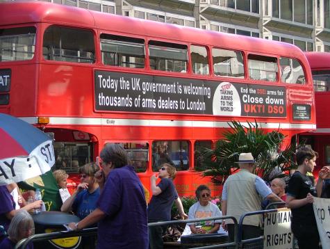 In a demonstration against the DSEI Arms Fair in London a red London bus has the banner 'Today the UK is welcoming thousands of arms dealers to London' displayed on it.