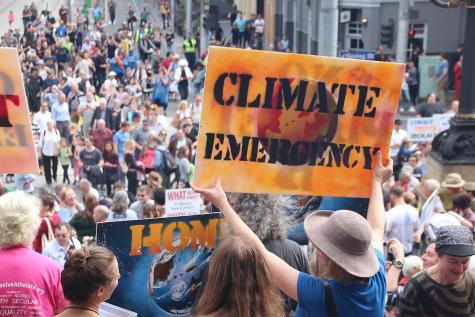 Thousands of Melburnians turned up and marched for science on April 22, Earthday 2017. In the foreground of the image there a large organe sign which says 'Climate Emergency'