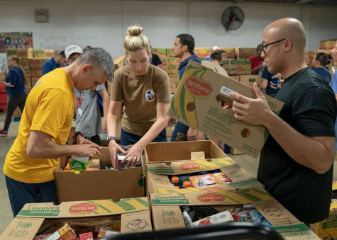 Volunteers work to pack up boxes at a food bank.