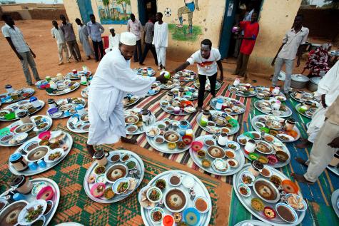 Two men set up trays with food in Al Tijane School in El Fasher for iftar, the evening meal that breaks the Muslim fast during the month of Ramadan. The African Union-United Nations Hybrid Operation in Darfur (UNAMID) sponsored the event that brought together nearly 500 people.