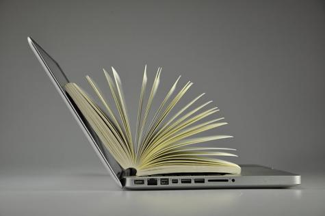 Side profile of a silver laptop with an open book inside.