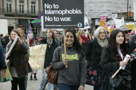 A group of protesters march through the street holding signs which say 'No To Islamophobia No To War'