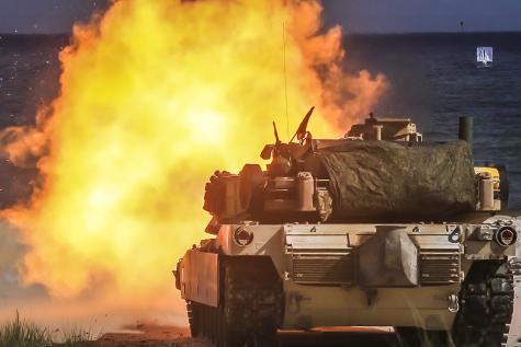 Live-fire training as part of exercise Baltic Operations in Poland. A tank is shown infront of the sea with a large explosion infront of it. 
