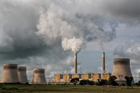 A powerplant with four huge towers send clouds of vapour and smoke into the sky.