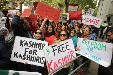 National demonstration for Kashmir at the Indian High Commission, London 10th August 2019. Many people stand behind a metal fence holding signs which say "Freedom for Kasmir" and "Free Kasmir"