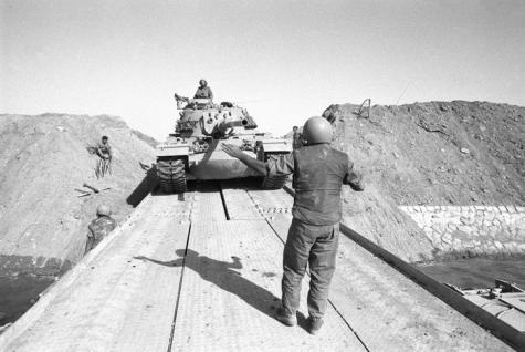 An army tank crosses the Suez canal on a make shift wooden bridge during the Suez Canal War.