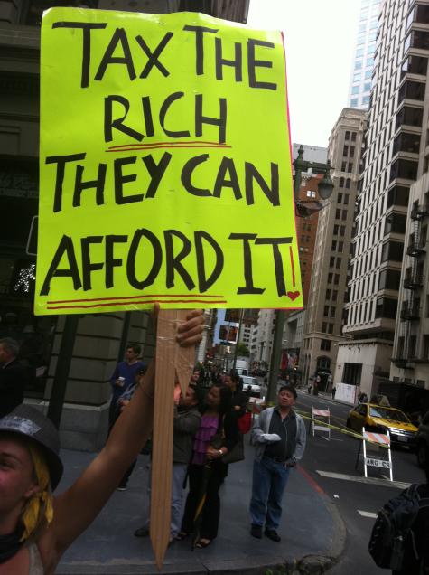 Tax the rich protest in the U.S. A protester hold up a sign that says 'Tax the rich, they can afford it".