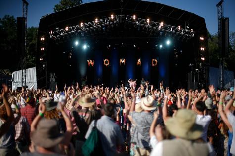 Audience enjoy dancing with a musician on the stage at WOMAD in the UK.