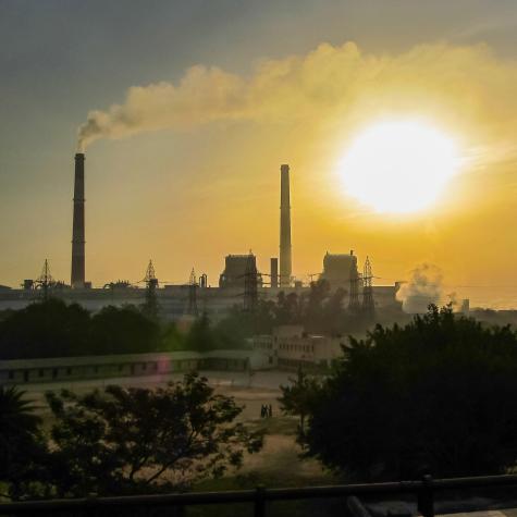A hazy sunrise in Delhi, with the sun muted behind dense layers of air pollution and smog.