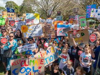 Colourful scene of many young children holding signs about climate change 