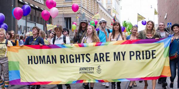 Amnesty International March through Finland, people hold a large banner displating the words 'human rights are my pride'