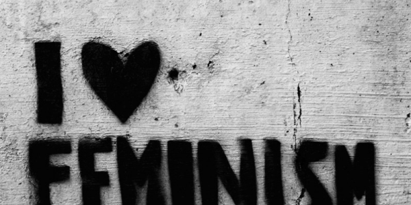 I heart feminism is spray painted in black on a gray cracked wall