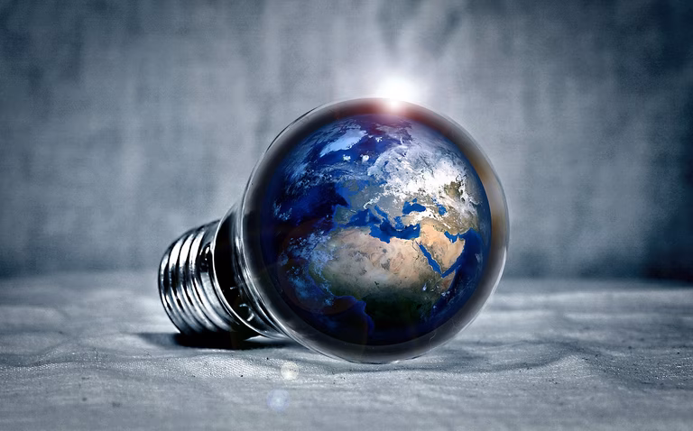 Image of the planet Earth sitting inside a lightbulb resting on its side.